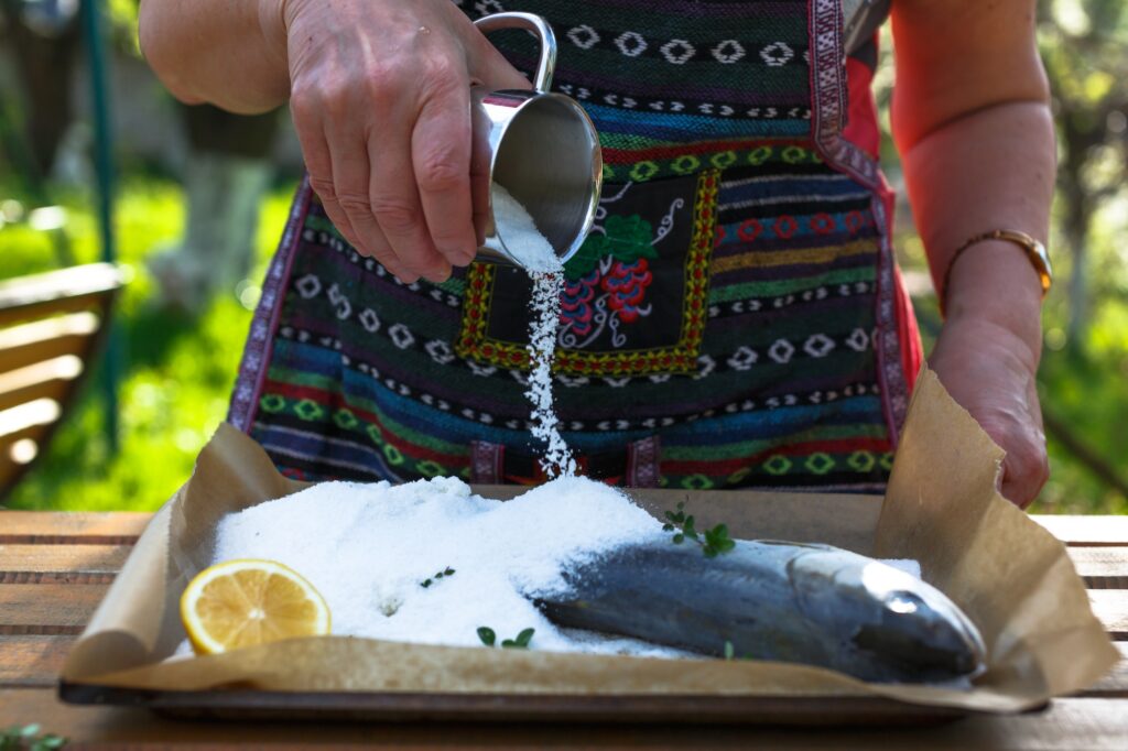 A woman cook a fish in a salt crust.